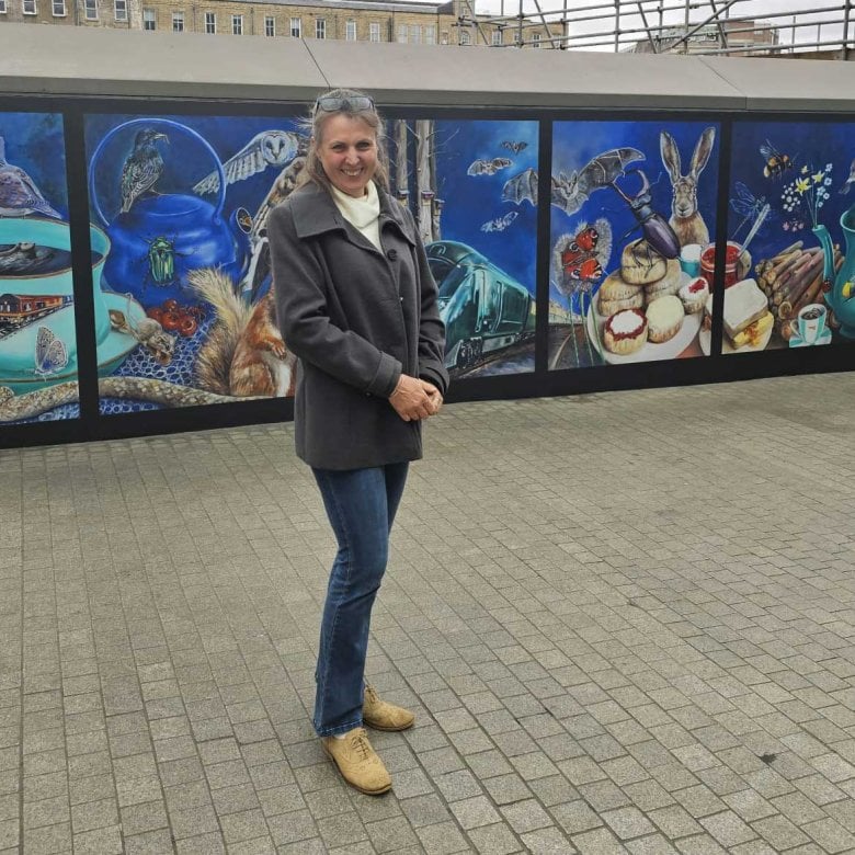 Artist and student Cindy Powell stood next to her mural of wildlife at Paddington station in London