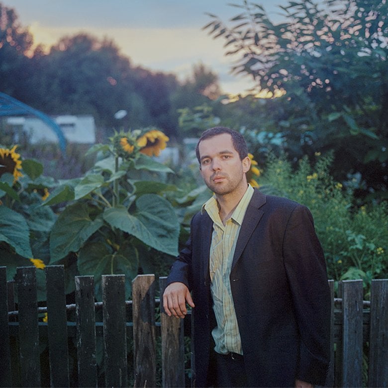 Benjamin Woods of band The Golden Dregs leaning on a fence 