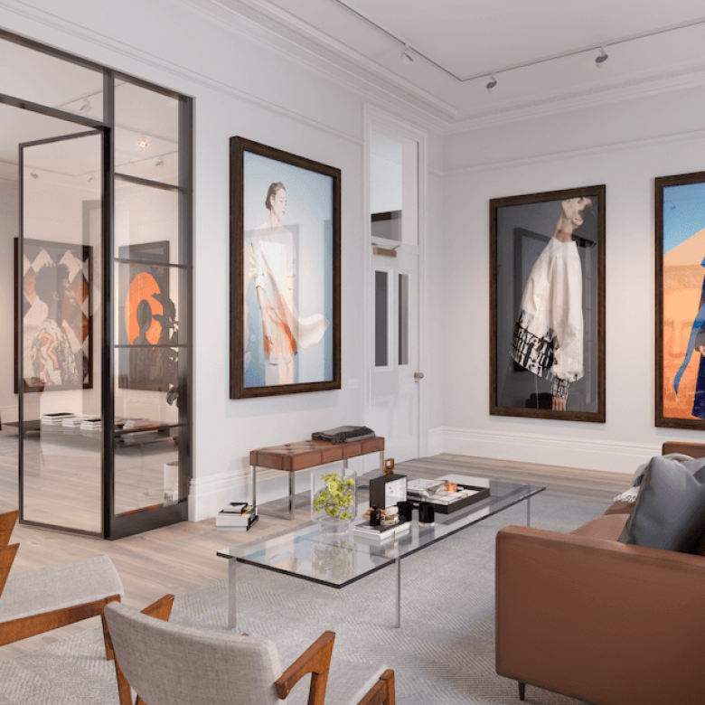 Interior design of a furnished apartment with a leather sofa, glass internal doors and large photos