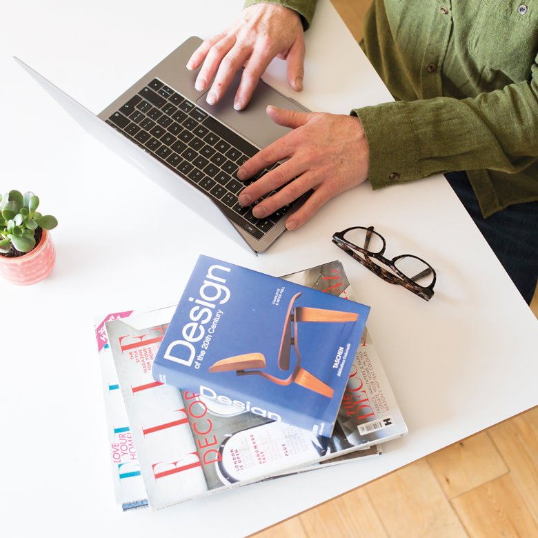 Person sat at laptop working with design book