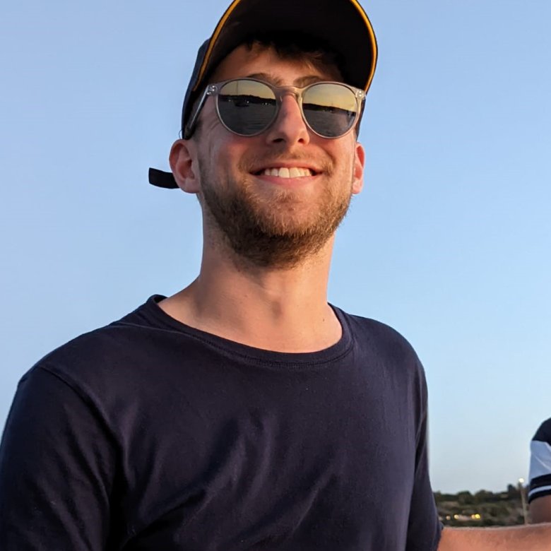 Man (Falmouth University graduate James Pearce) wearing black tshirt, sunglasses and cap