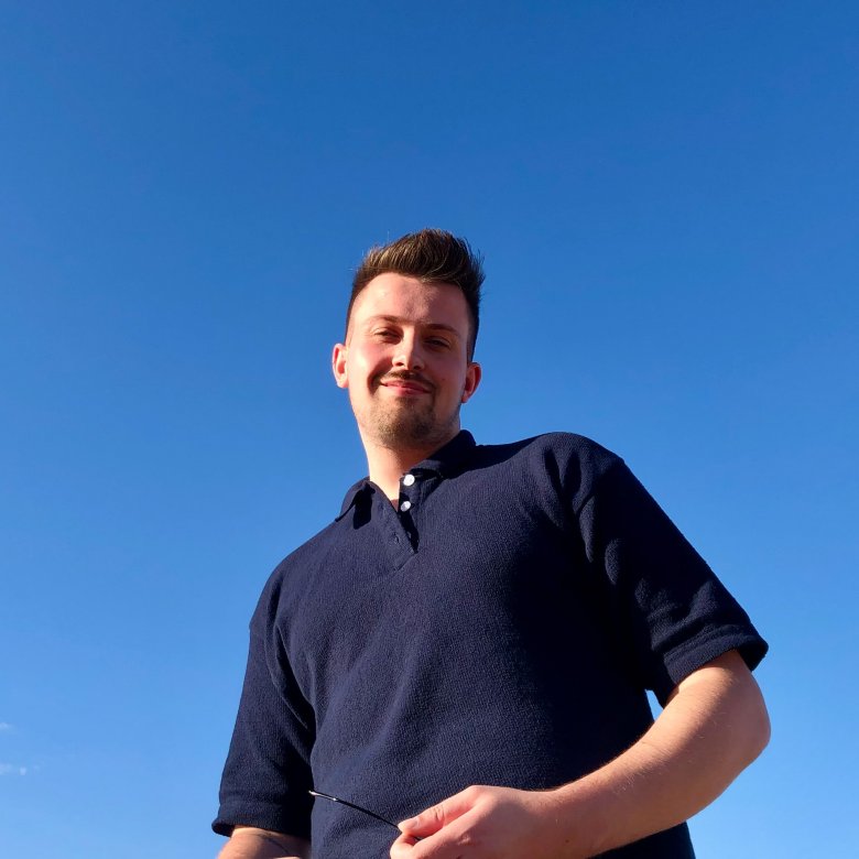 Graduate Michael Chubb smiling behind a blue sky