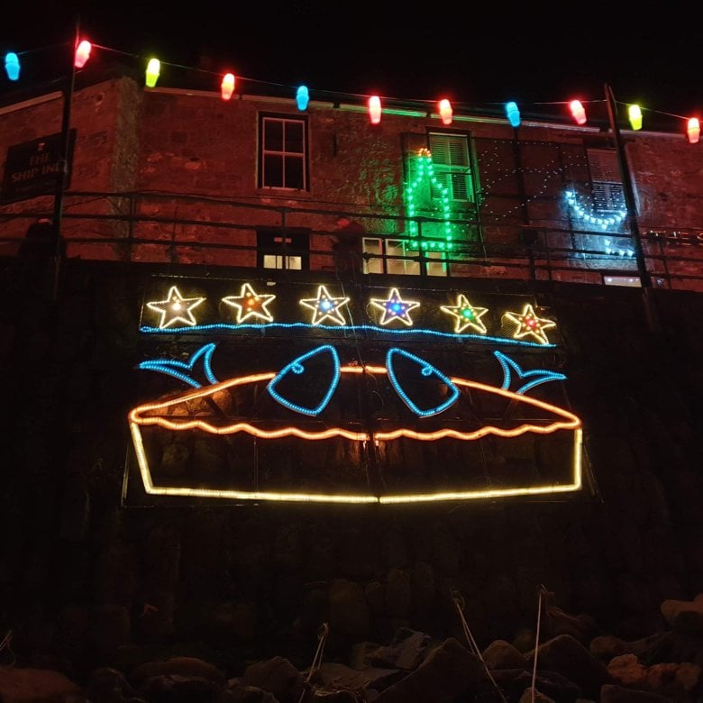 The mousehole lights of stargazy pie with fish heads coming out of a pie