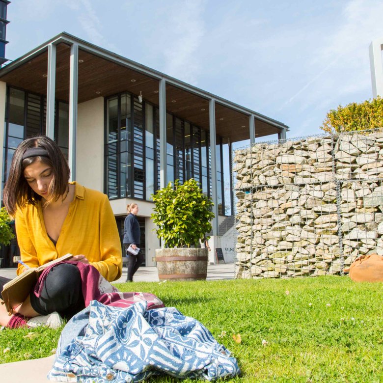 Students sit and read on the grass outside the Stannary