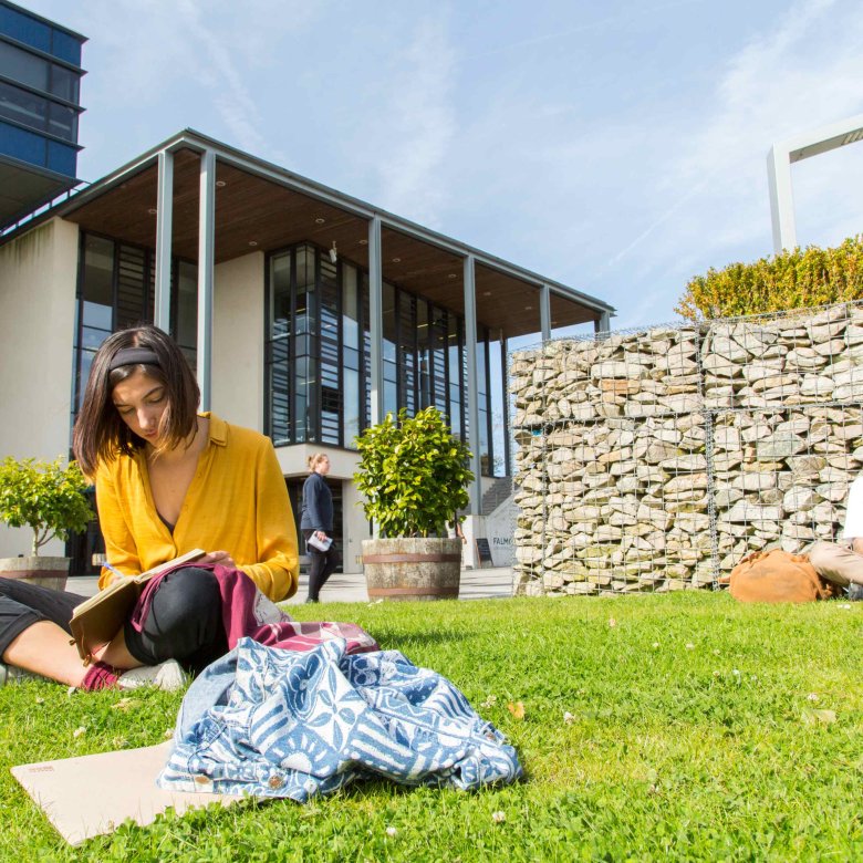 Students sit and read on the grass outside the Stannary
