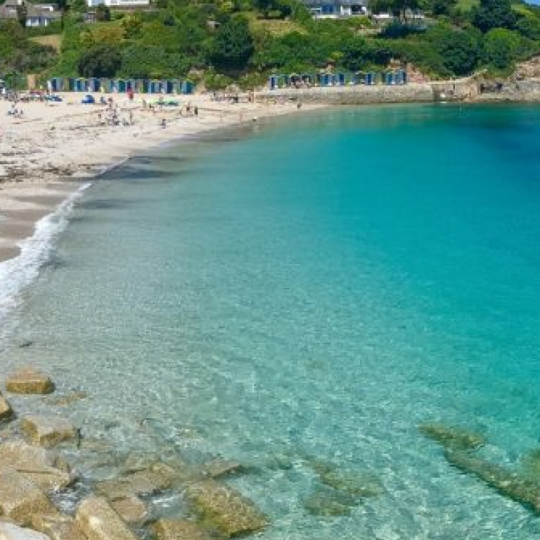 View of Swanpool Beach with turquoise water and beach huts
