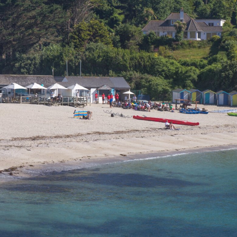 Swanpool Beach from the water with the beach, cafe and beach huts in the background