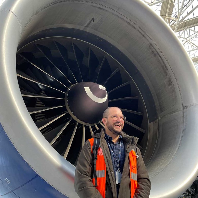 UX Design online tutor Cralos stood next to an airplane engine