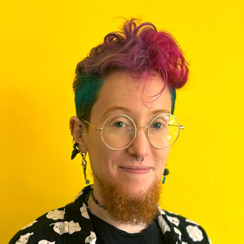 A person smiling into the camera against a yellow background