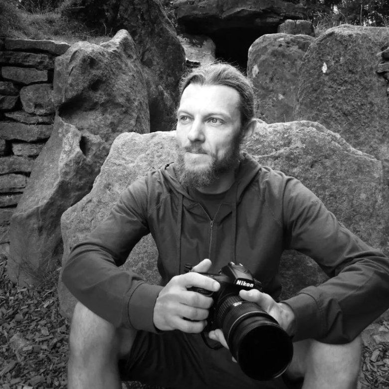 Black and white photograph of a man holding a camera