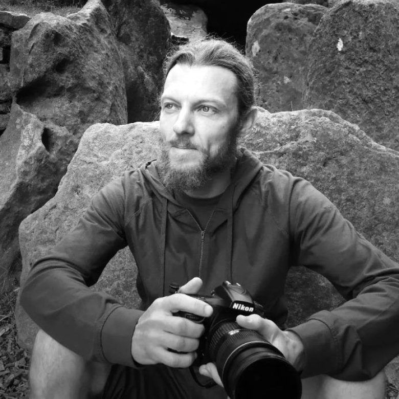Black and white photograph of a man holding a camera
