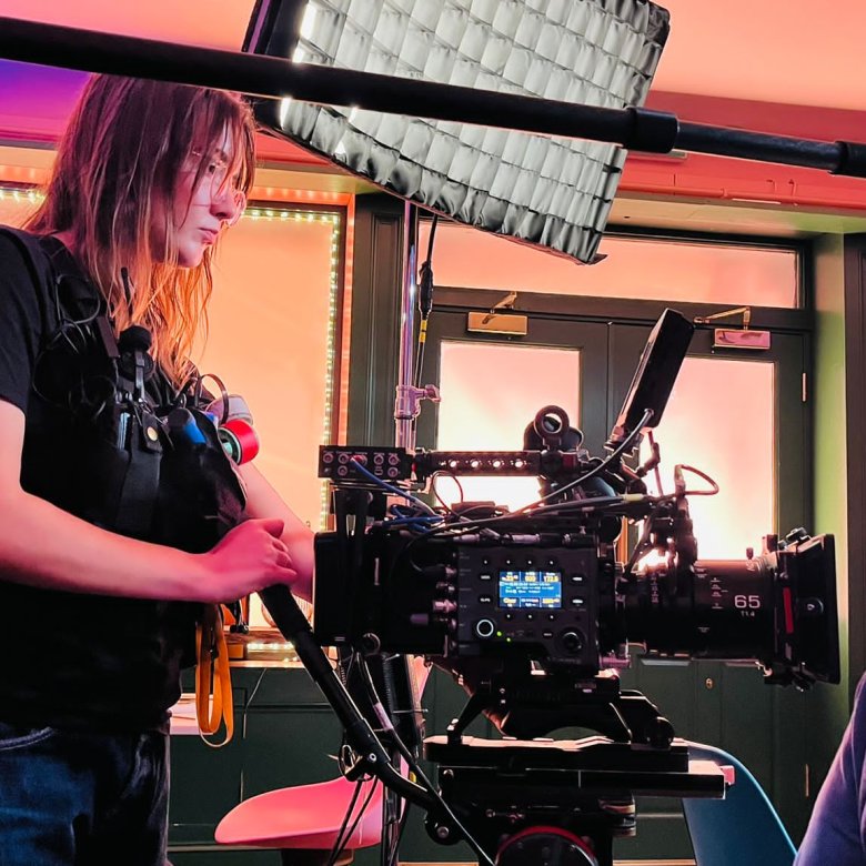 Film graduate Faith Glenister operating a camera on a film set