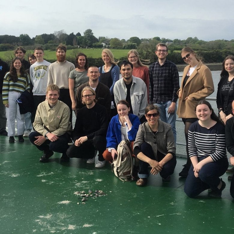 Graphic design staff, students and alumni project team photo on board a boat