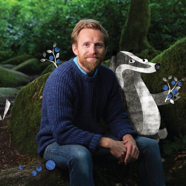 Huw Lewis Jones sitting in the woods with an illustration of a badger, bird and flowers