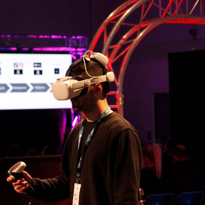 A man wearing a VR headset and holding a control