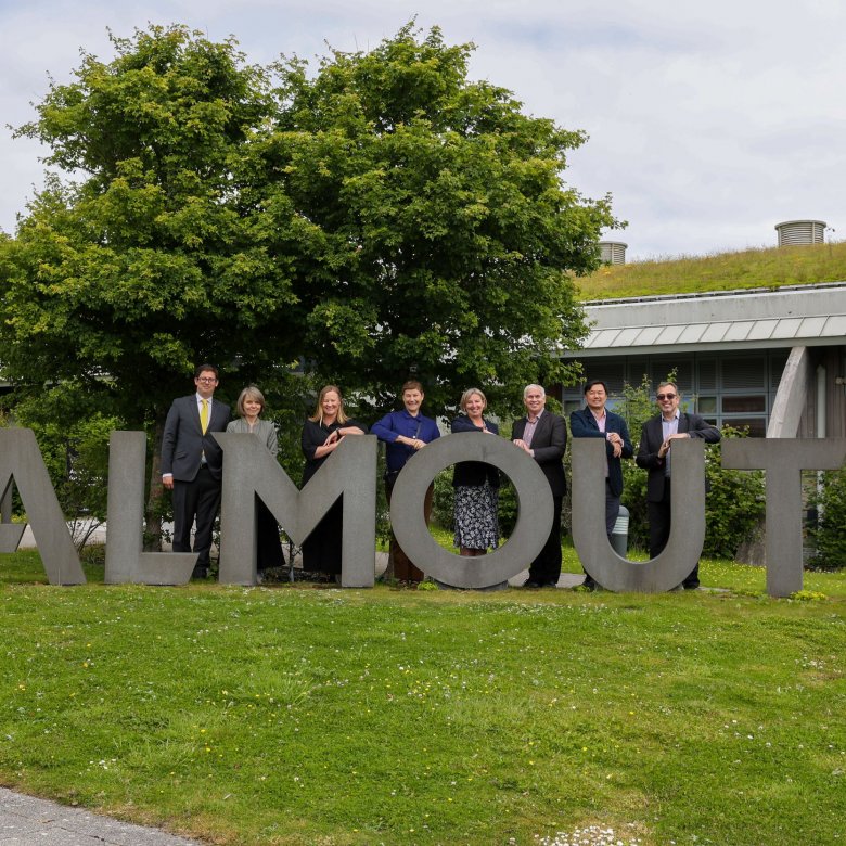 Delegates from LASALLE and Falmouth University standing behind large concrete letters reading 'FALMOUTH'