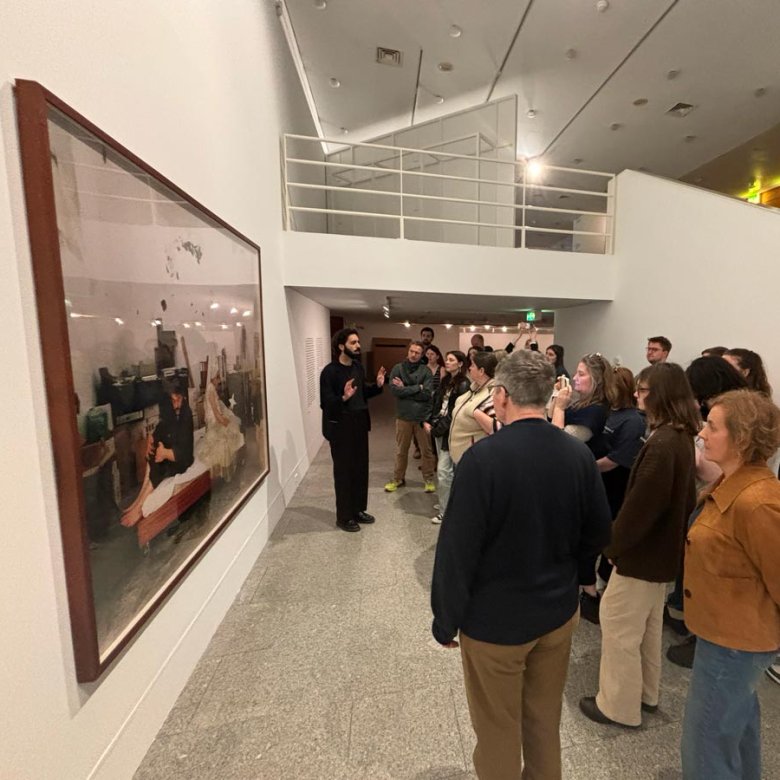 A group of students looking at a large photograph displayed in a gallery