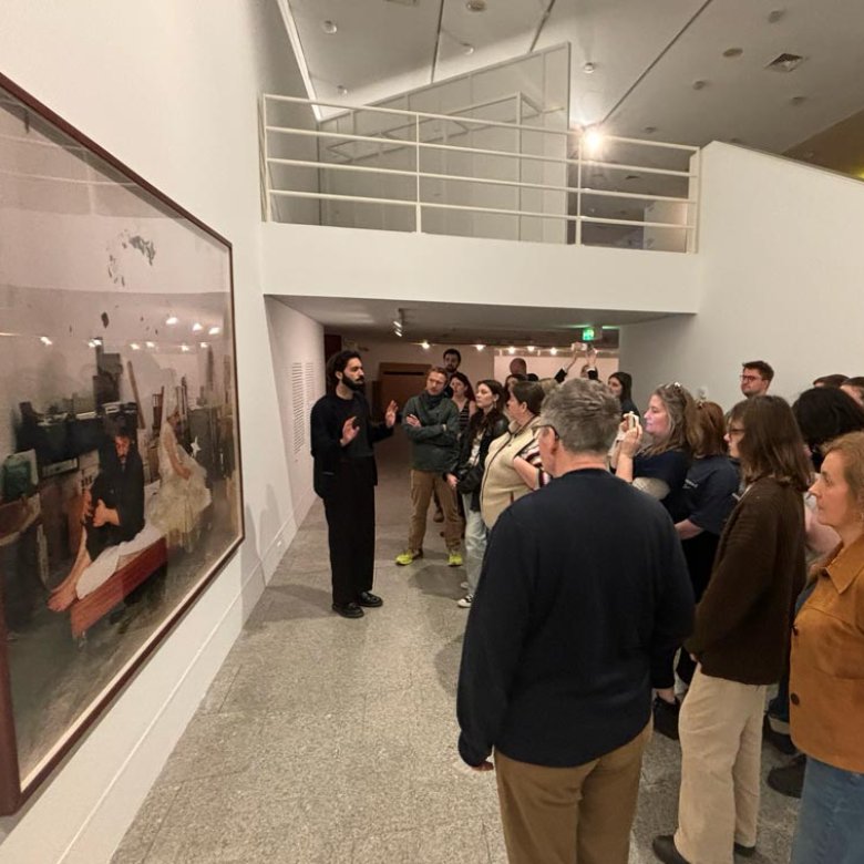 A group of students looking at a large photograph displayed in a gallery