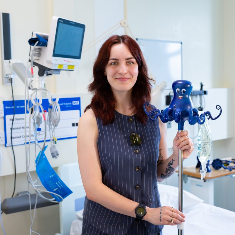 Image of person holding an IV drip holder in a hospital
