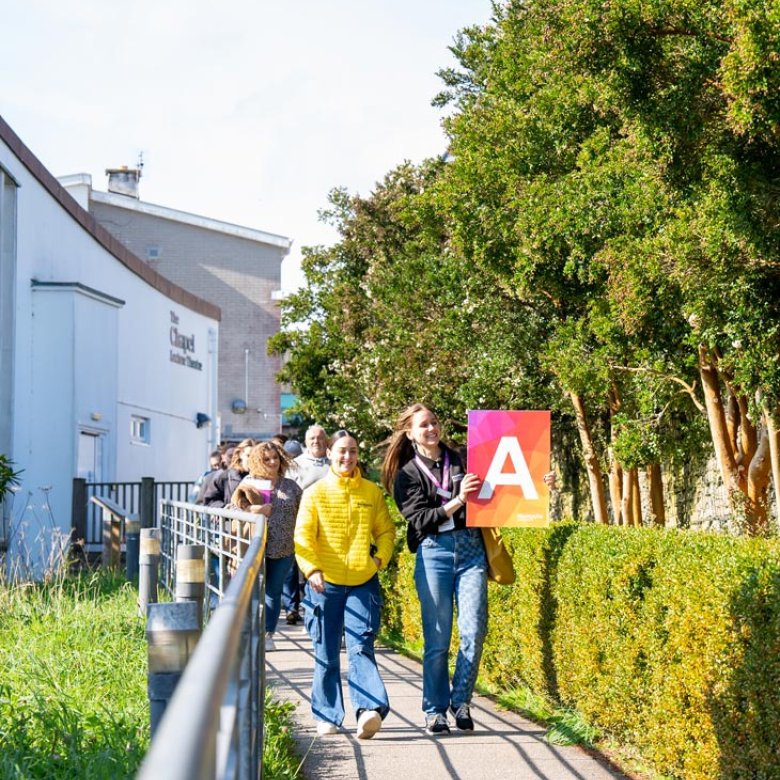 A group of people walking outside at a Falmouth University Open Day