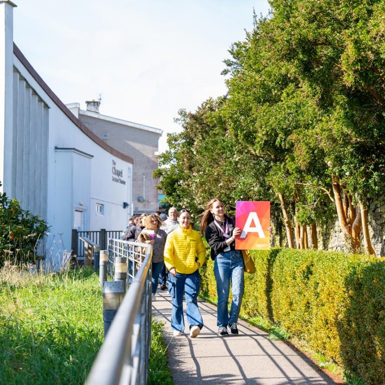 A group of people walking outside at a Falmouth University Open Day