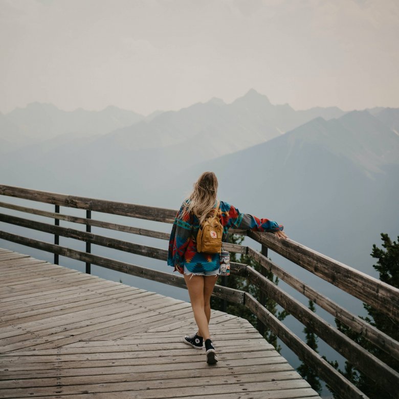 A young woman looks out at a mountain range