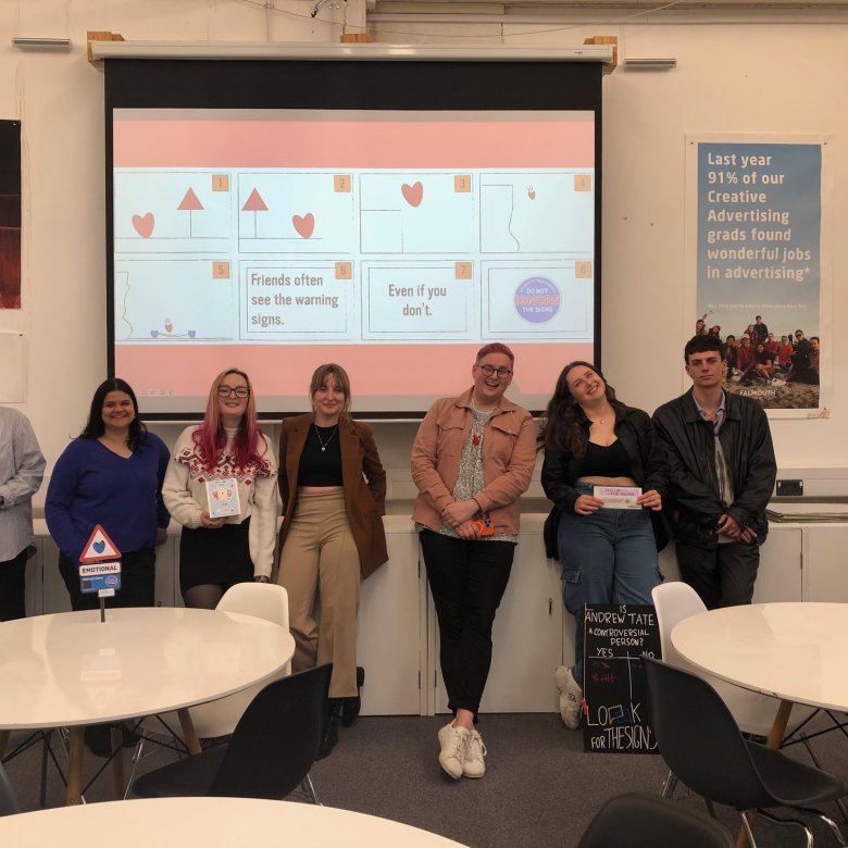 A group of Creative Advertising student standing in front of a screen in a seminar room