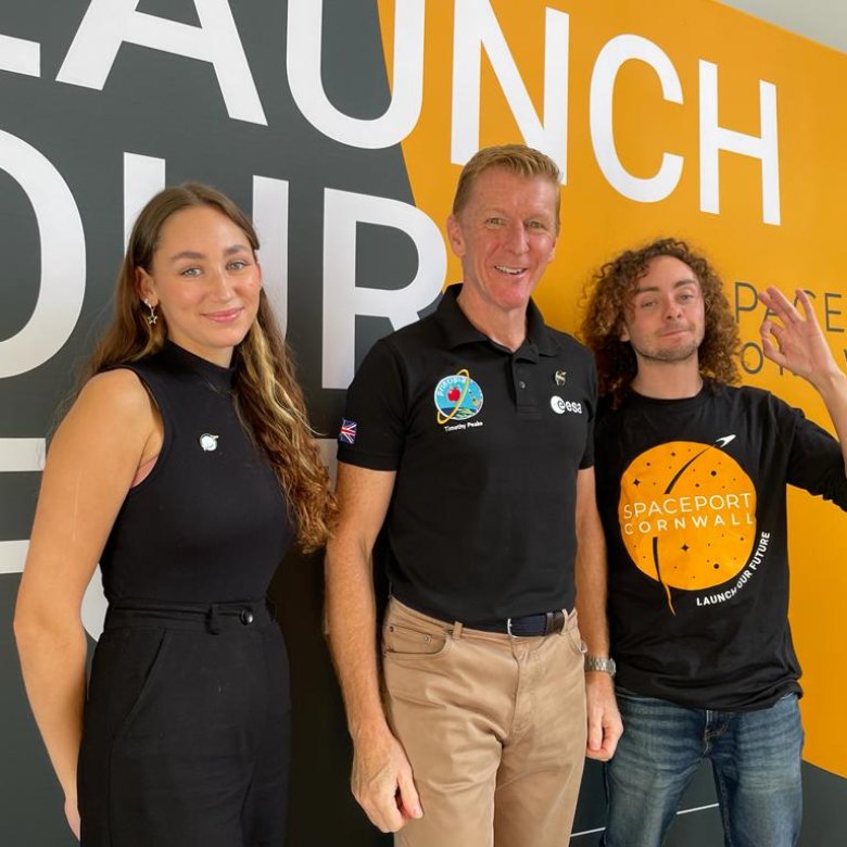 Graduate Rachel Harrison and student Ben Pisacane stand either side of Time Peake in front of backdrop that reads 'Launch our future'.