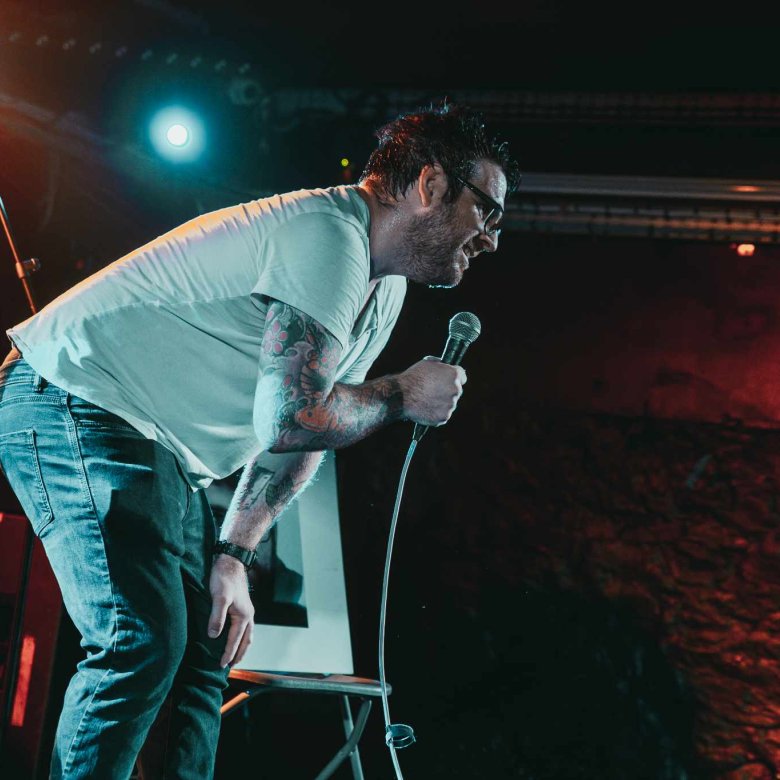 A man on stage performing a stand-up comedy routine