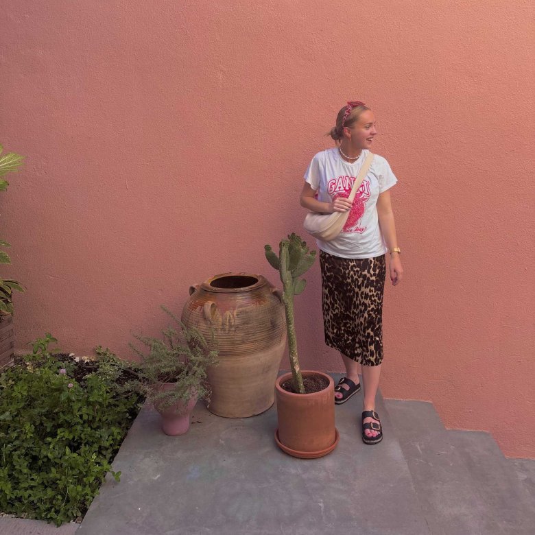 A woman stood outside a pink building