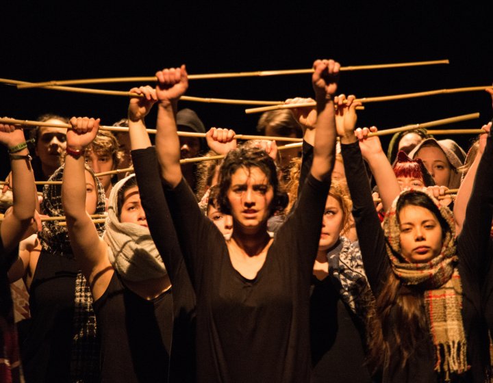 Group of students holding sticks in the air.