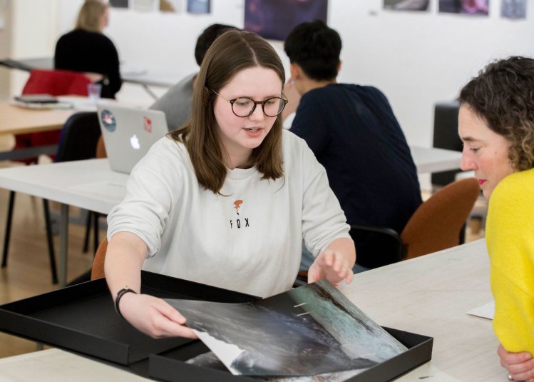 Falmouth University student showing photography portfolio to lecturer.