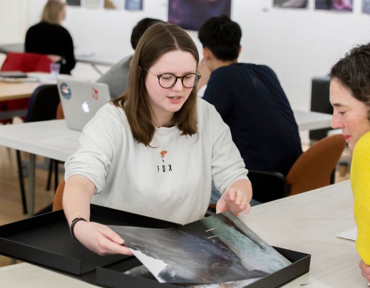 Falmouth University student showing photography portfolio to lecturer.
