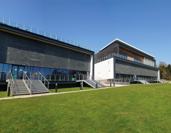 Exterior of the AMATA building on Penryn Campus with grass and blue sky