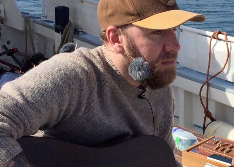 John Lamb singing on a boat for his latest album.