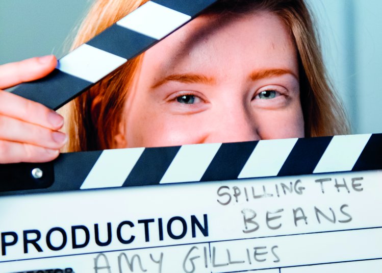 Student, Amy Gillies, peeking though a clapperboard.
