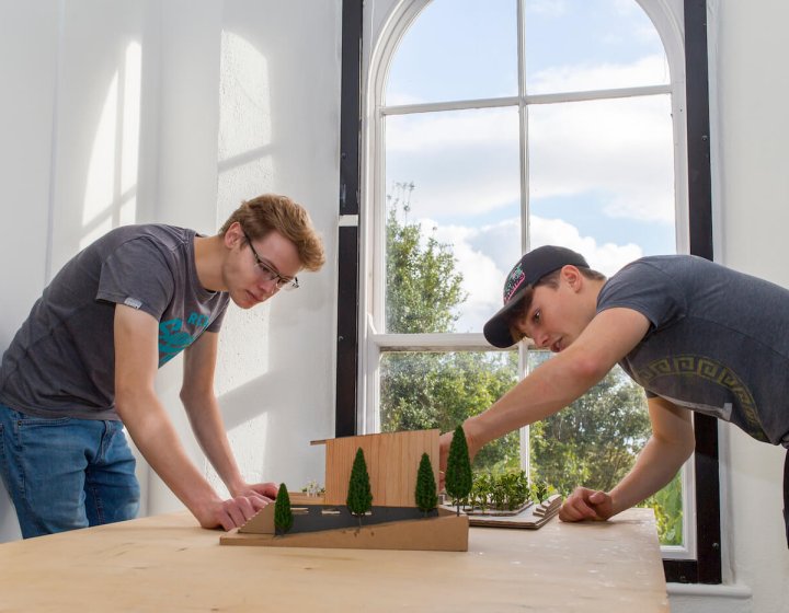 Two Falmouth University Architecture students examining model
