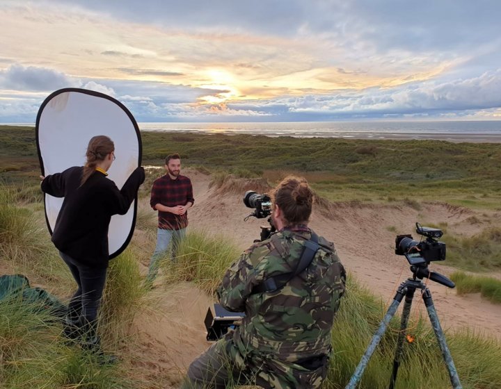 Students filming on beach