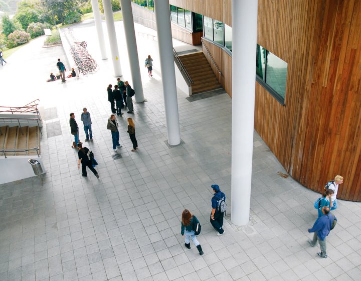 View down onto Penryn campus foyer and people walking and chatting.