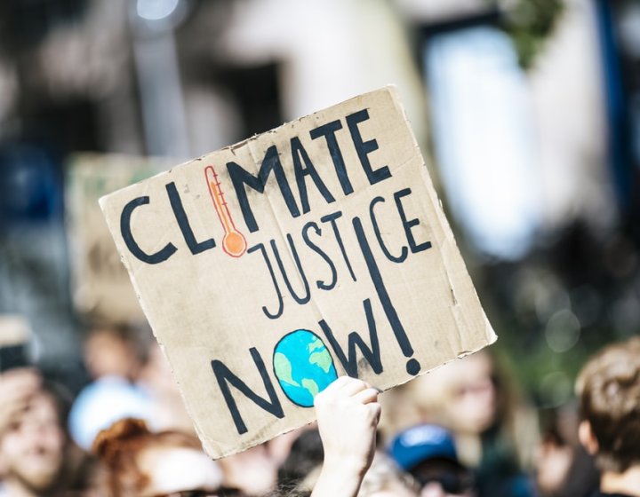 Image of protest placard reads 'Climate Justice Now'