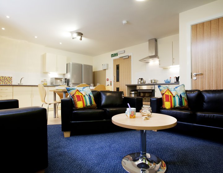 The Sidings' open-plan living area with kitchen and cluster of soft seating 