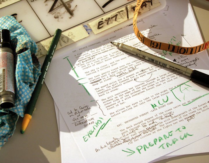 A printed piece of paper with green ink annotations and pens