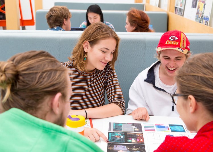 Four Falmouth University students sat around a table looking at a print out