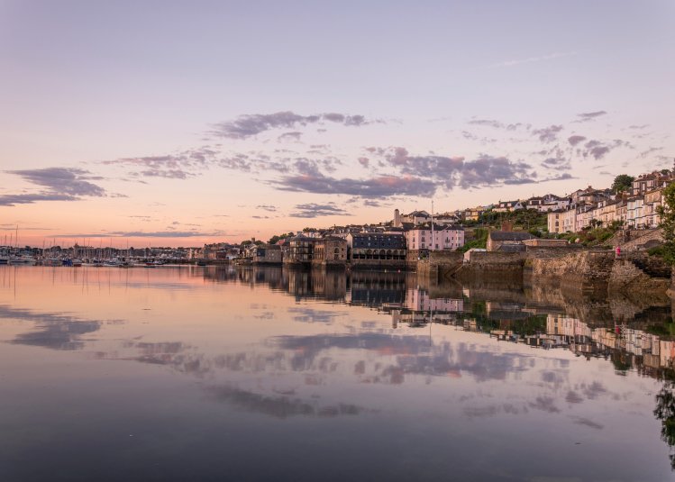 Buildings on the edge of the water with a purple sky
