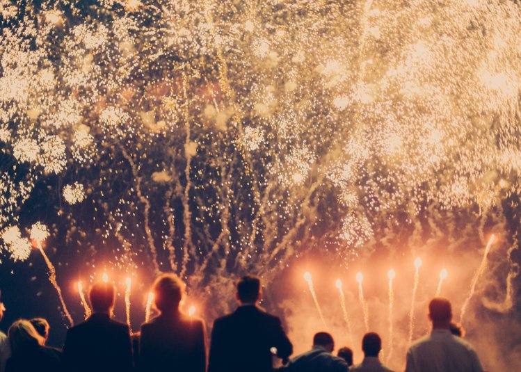 A group of people looking at a huge orange firework display