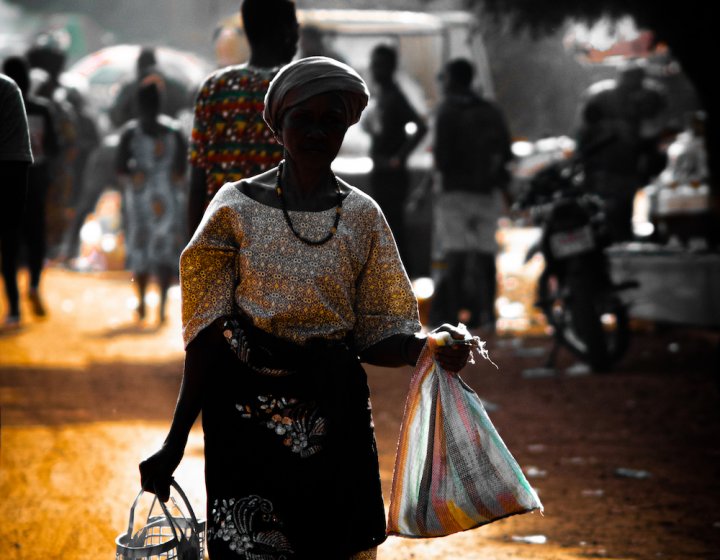 Woman in African dress carrying bags