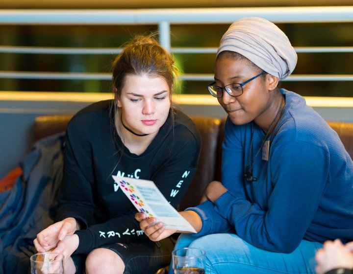 Falmouth international students reading a leaflet together.