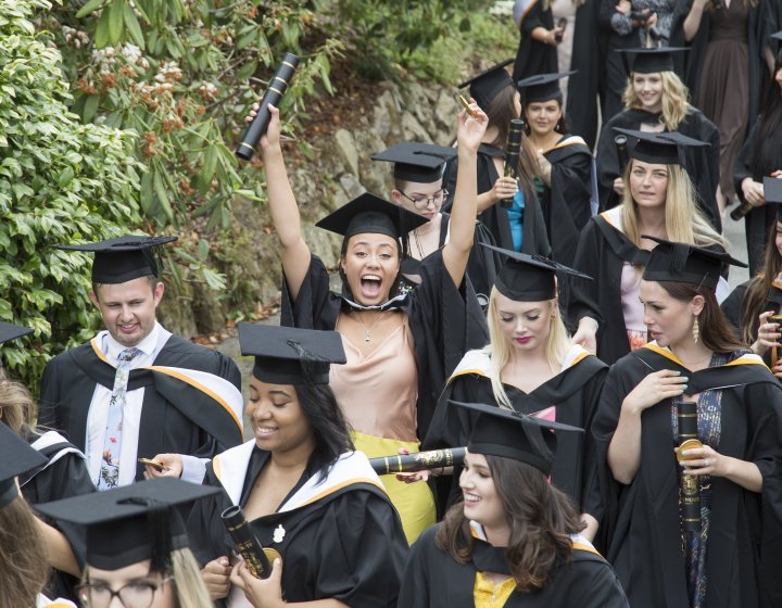 Falmouth University graduation 2019 – graduates walking through gardens in gowns and hats. 