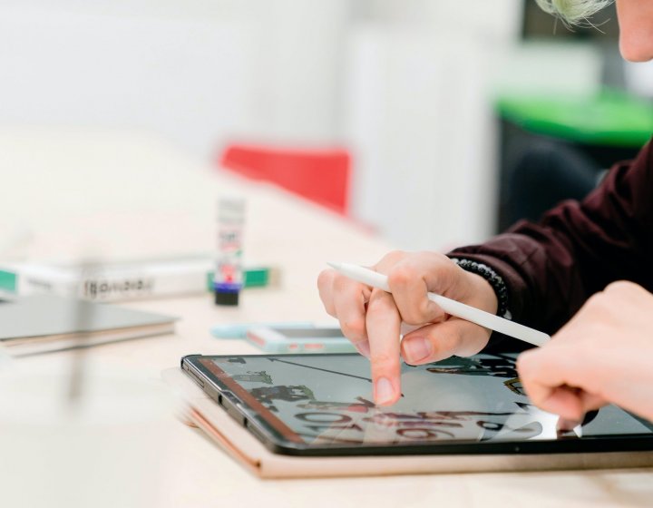 A student drawing on an iPad with a pen