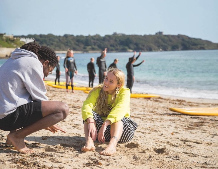 Two students talking on the beach in Falmouth